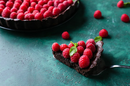 Spatula with piece of tasty raspberry pie and mint on color background, closeupの写真素材