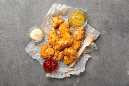 Parchment with popcorn chicken and sauces on gray backgroundの写真素材