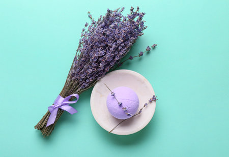 Bowl with bath bomb and lavender flowers on color backgroundの写真素材