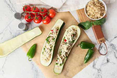 Quinoa stuffed zucchini boats and ingredients on light backgroundの写真素材