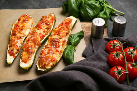 Meat stuffed zucchini boats and ingredients on dark backgroundの写真素材