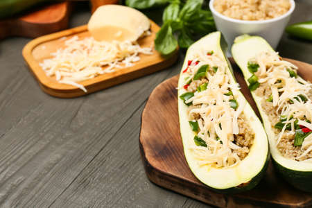 Board with quinoa stuffed zucchini boats on wooden background, closeupの写真素材