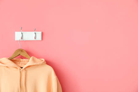 Modern hoodie hanging on pink wall