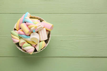Bowl with tasty marshmallows on color wooden backgroundの写真素材