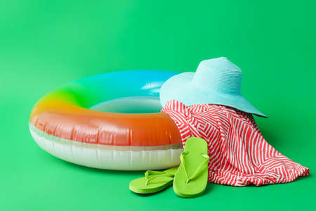Inflatable ring, dress, hat and flip-flops on color backgroundの写真素材