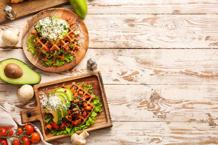 Composition with tasty Belgian waffles and vegetables on light wooden backgroundの写真素材