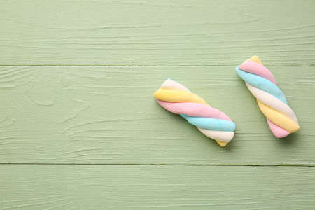 Tasty twisted marshmallows on color wooden backgroundの写真素材