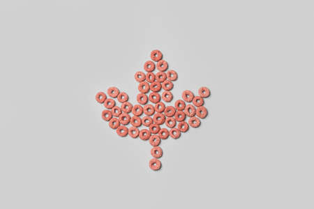 Maple leaf made of cornflakes on light background. Canadian flag concept