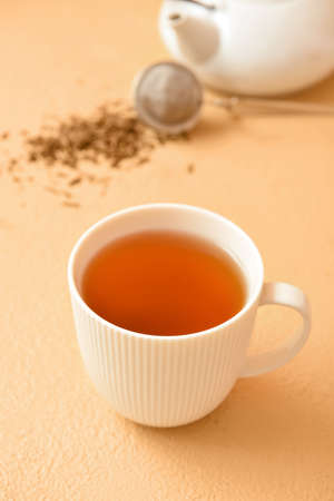 Cup of tasty hojicha green tea on beige backgroundの写真素材