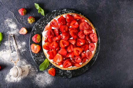 Board with tasty strawberry pie on dark backgroundの写真素材