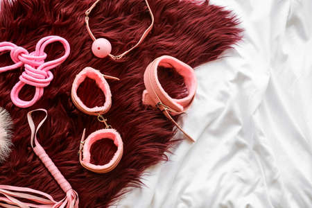 Different BDSM sex toys on bed