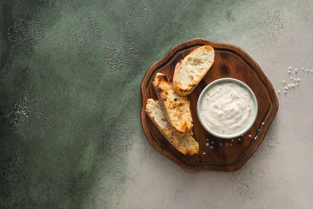 Bowl of tasty Caesar salad and croutons on grunge backgroundの写真素材