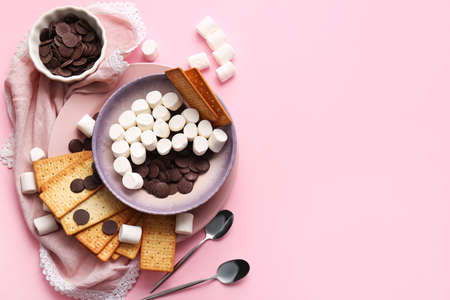 Ingredients for preparing S'mores dip on pink background