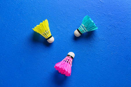 Badminton shuttlecocks on color background