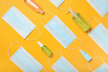 Medical masks and hand sanitizers on color backgroundの写真素材
