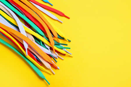 Many different shoelaces on yellow background, closeupの写真素材