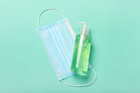 Medical mask and hand sanitizer on color backgroundの写真素材