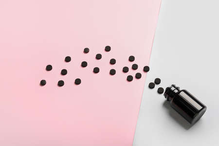 Bottle with activated carbon pills on color backgroundの写真素材