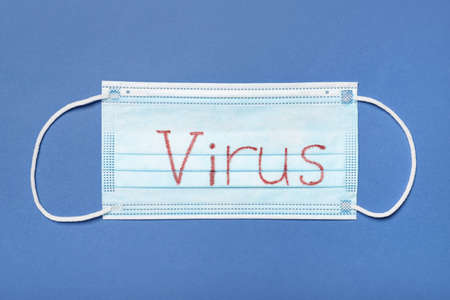 Surgical mask with word VIRUS on color background. protection conceptの写真素材