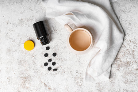 Activated carbon pills and cup of water on grunge backgroundの写真素材