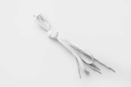 Shoe laces tied in knot on white background