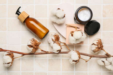 Composition with different cosmetic products and cotton branch on light tileの写真素材
