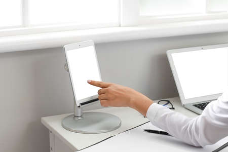 Female doctor working with tablet computer in clinic, closeup
