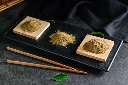 Board with hojicha powder on black backgroundの写真素材