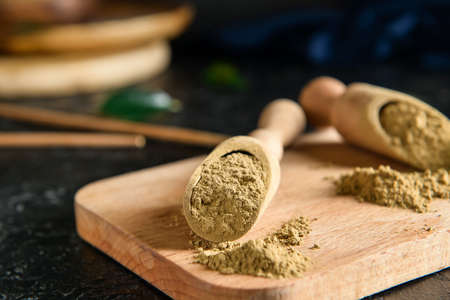 Scoops with hojicha powder on black background, closeup