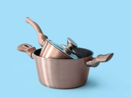 Cooking pots on color background