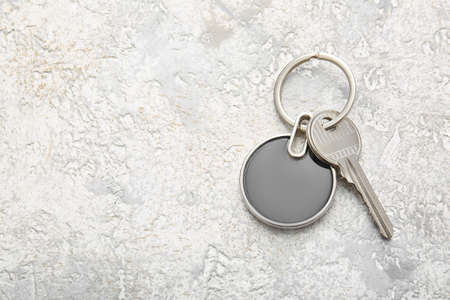 Key with stylish round keychain on light backgroundの写真素材
