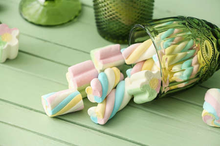 Glass with sweet marshmallows on color wooden backgroundの写真素材