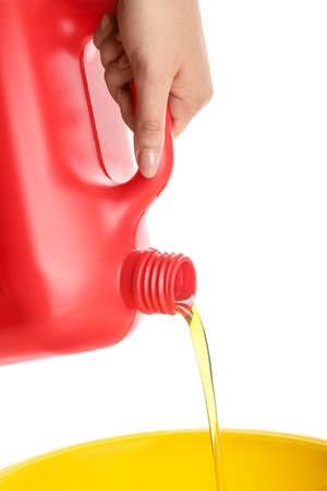 Woman pouring motor oil from canister against white background