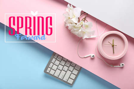 Composition with alarm clock, computer keyboard and earphones on color background. spring forward