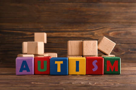 Word AUTISM made of cubes on wooden backgroundの写真素材