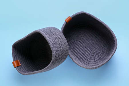 Stylish knitted baskets on blue background