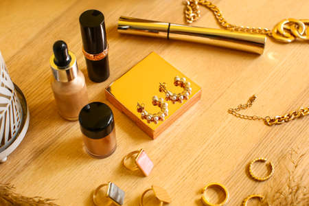 Beautiful jewelery and cosmetics on wooden table