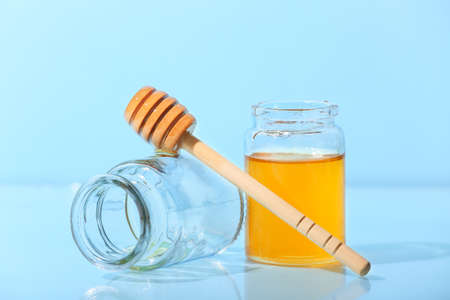 Jar with sweet honey and dipper on blue backgroundの写真素材