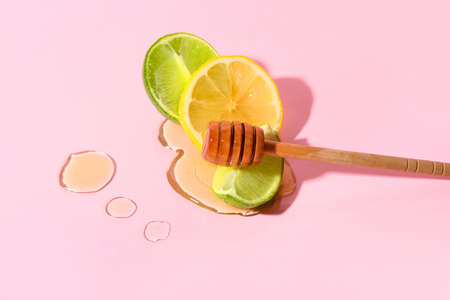 Pieces of lime, lemon and honey on color backgroundの写真素材