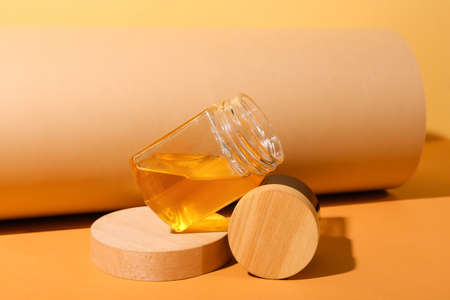 Composition with jar of cosmetic product and honey on color backgroundの写真素材
