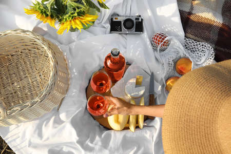 Young woman having festive picnic with tasty food and wine, top viewの写真素材