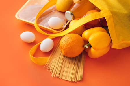 Eco bag with different products and bottle of juice on color background, closeupの写真素材