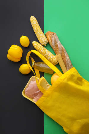 Eco bag with scattered products on green and black backgroundの写真素材