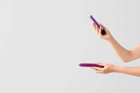 Female hands with vibrators on light backgroundの写真素材