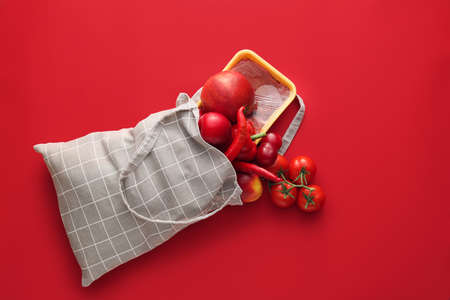Eco bag with fruits, vegetables and meat on color backgroundの写真素材