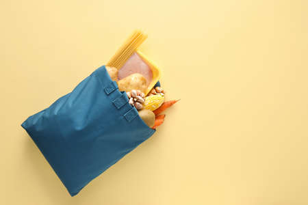 Eco bag with vegetables, pasta and meat on color backgroundの写真素材