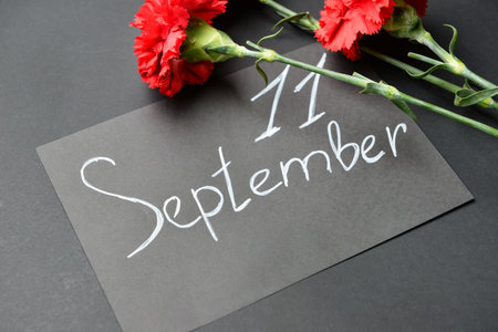 Card with date of National Day of Prayer and Remembrance for the Victims of the Terrorist Attacks and flowers on dark backgroundの写真素材