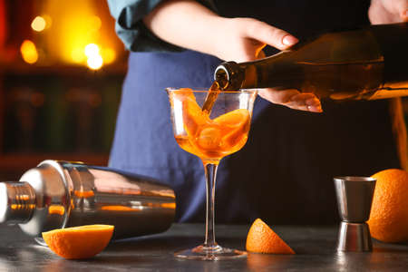 Woman preparing tasty aperol spritz cocktail at tableの写真素材