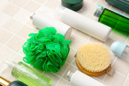 Bath accessories and cosmetics on light tiles, closeup