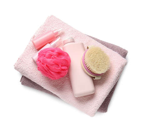 Towels, cosmetic products, sponge and massage brush on white background